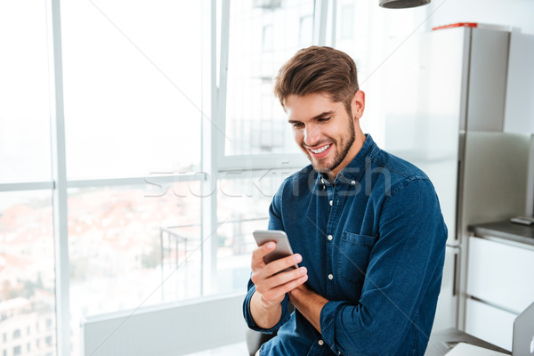 [[stock_photo]]: Jeune · homme · smartphone · souriant · photos · regarder