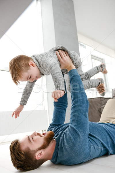 Happy bearded father playing with his little cheerful son Stock photo © deandrobot
