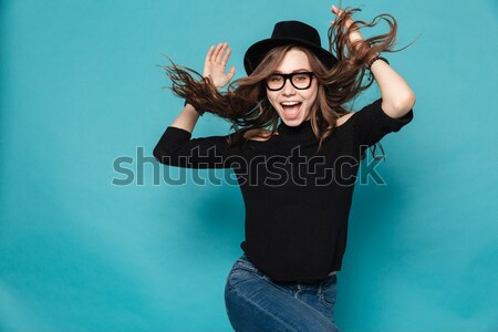 Pretty modern young woman in black hat dancing and whirling Stock photo © deandrobot