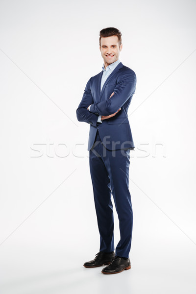 Full length image of smiling business man with crossed arms Stock photo © deandrobot