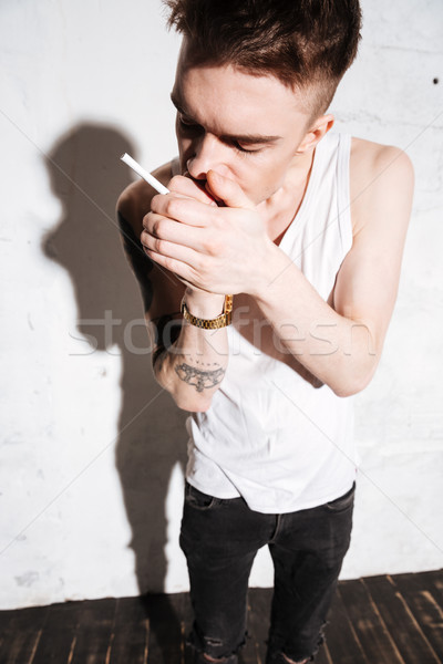Junger Mann stehen Stock Zigarette posiert Bild Stock foto © deandrobot