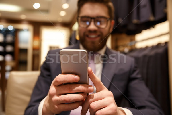 Happy young bearded businessman chatting by phone. Stock photo © deandrobot