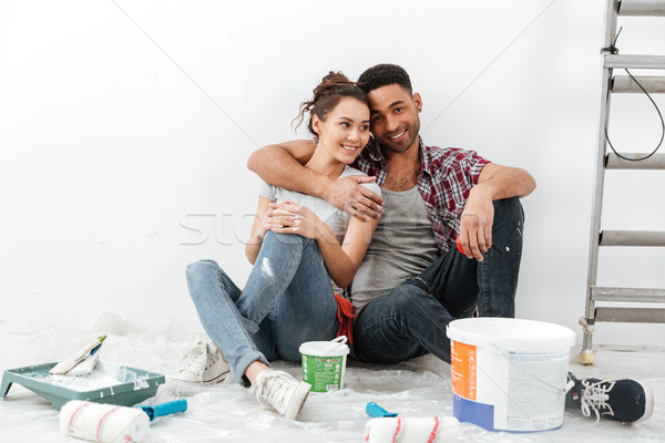 Happy multiethnic young couple renovating home and hugging Stock photo © deandrobot