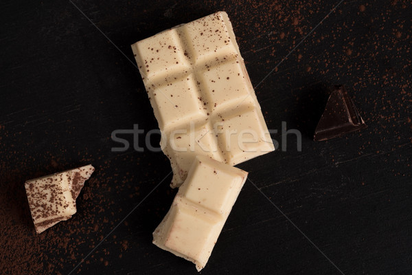 Top view of white and dark crashed chocolate bar tiles Stock photo © deandrobot