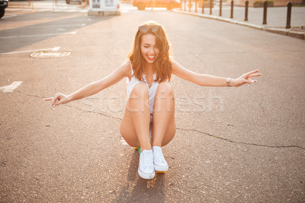 Glimlachend jonge vrouw skateboard buitenshuis afbeelding naar Stockfoto © deandrobot