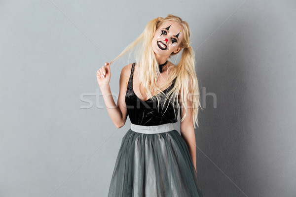 Portrait of a smiling playful woman in halloween clown make-up Stock photo © deandrobot