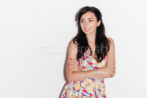 Smiling brunette woman posing in studio with crossed arms Stock photo © deandrobot
