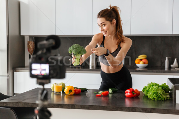 Smiling healthy young girl recording her blog episode Stock photo © deandrobot