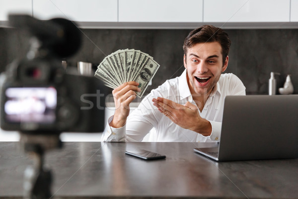 Satisfied young man filming his video blog episode Stock photo © deandrobot