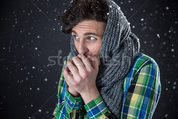 Young handsome man looking away with snow on background Stock photo © deandrobot
