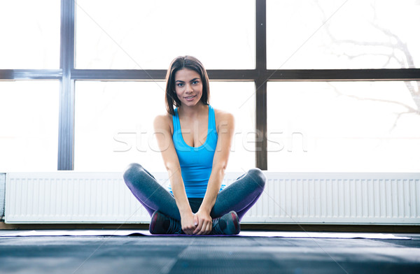 Young beautiful woman sitting on yoga mat Stock photo © deandrobot