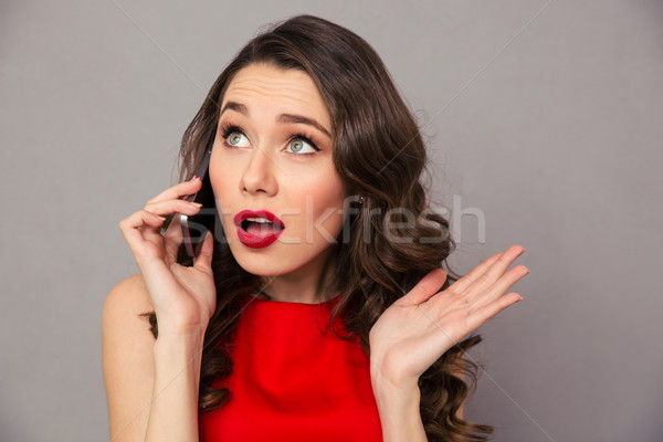 Figyelmes nő beszél telefon portré szürke Stock fotó © deandrobot