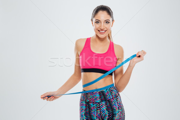 Fitness woman measuring waist with tape Stock photo © deandrobot