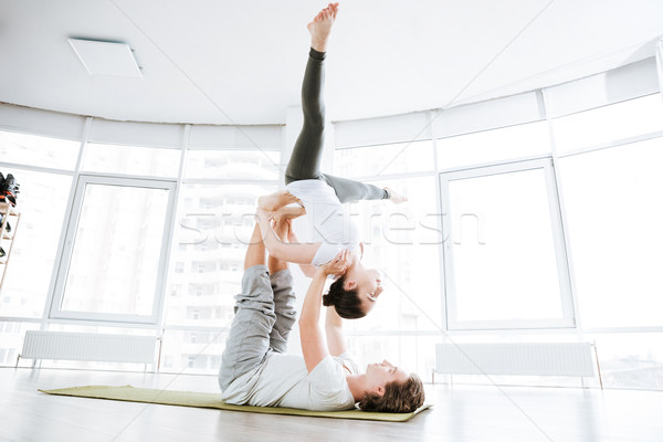 Relaxed young couple balancing and doing acro yoga Stock photo © deandrobot