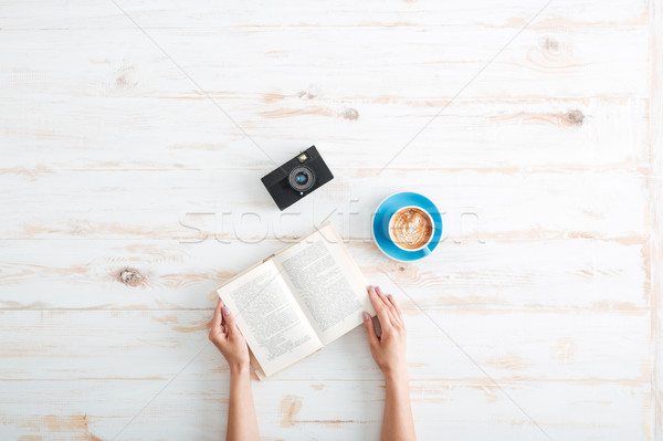 Female hands holding book on the wooden desk Stock photo © deandrobot