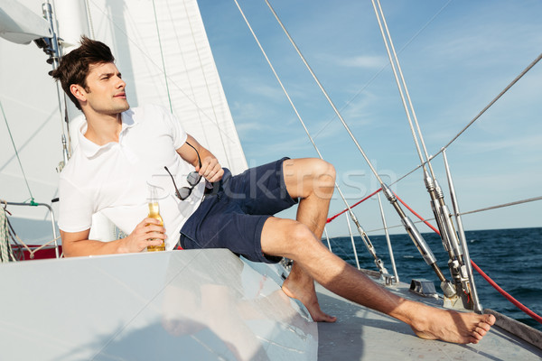 Knap jonge man drinken bier jacht Stockfoto © deandrobot