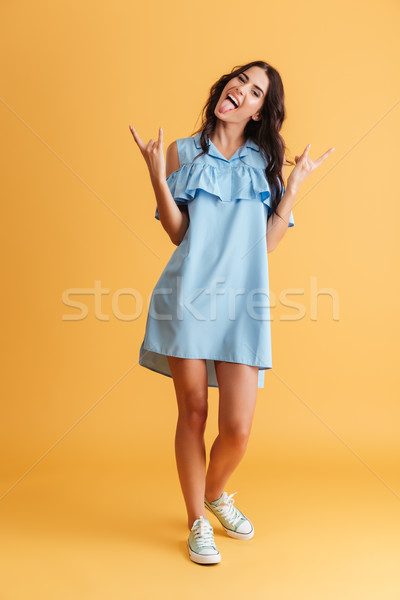 Young brunette woman showing rock gesture with hands Stock photo © deandrobot