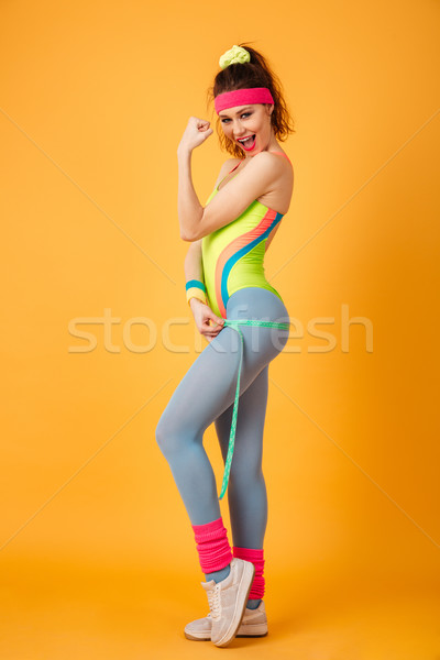 Jeune femme athlète semailles biceps mètre à ruban [[stock_photo]] © deandrobot