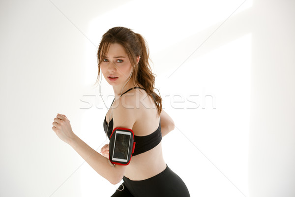 Concentrated sports woman running looking at camera. Stock photo © deandrobot