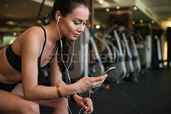 Amazing sports lady sitting indoors at gym Stock photo © deandrobot