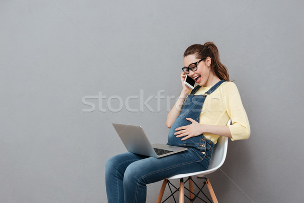 Foto stock: Embarazadas · alegre · dama · usando · la · computadora · portátil · ordenador · hablar