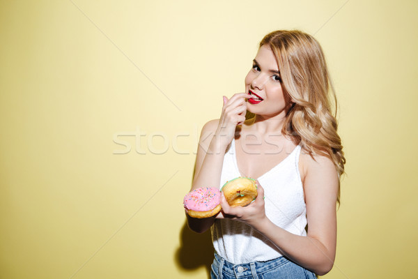Woman with bright lips makeup holding donuts. Stock photo © deandrobot