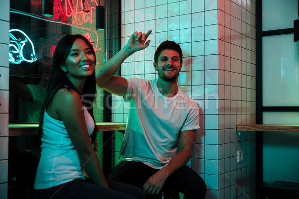 Multiethnic loving couple sitting in cafe looking aside. Stock photo © deandrobot