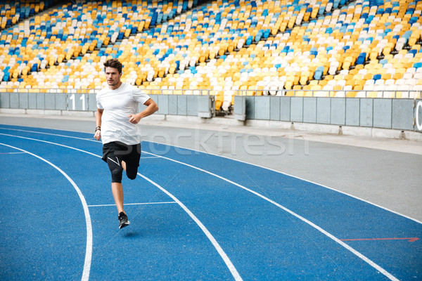Young sprinter running on athletics track Stock photo © deandrobot