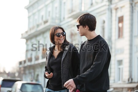 Smiling young woman walking outdoors with her brother. Stock photo © deandrobot
