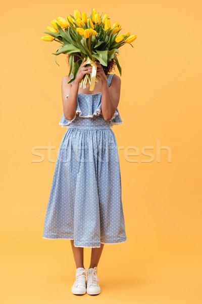 Full-length portrait of african woman hiding behind bouquet flow Stock photo © deandrobot