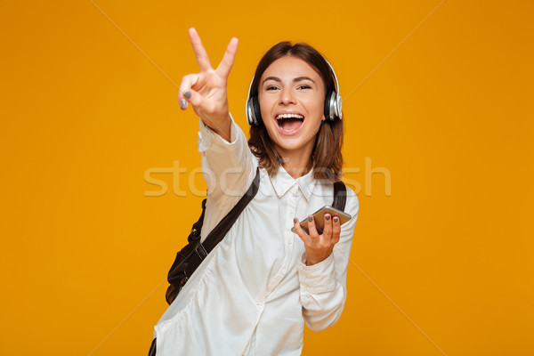 Retrato alegre colegiala uniforme auriculares Foto stock © deandrobot