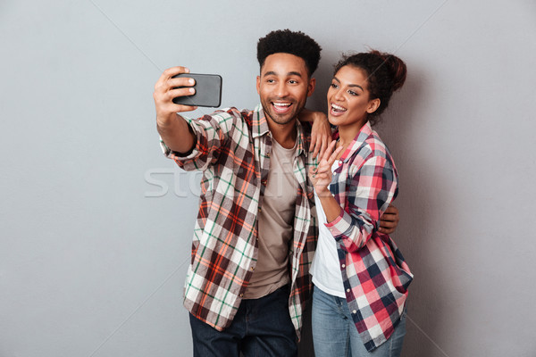 Portrait of a loving young african couple hugging Stock photo © deandrobot