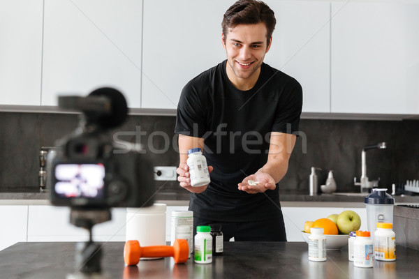 Cheerful young man filming his video blog episode Stock photo © deandrobot