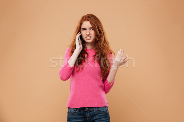Portrait of a confused pretty redhead girl talking Stock photo © deandrobot