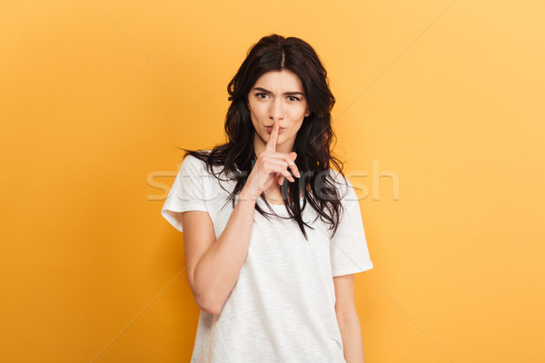 Cute woman make silence gesture. Stock photo © deandrobot