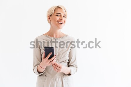 Portrait of a young happy woman with arms folded on gray background Stock photo © deandrobot