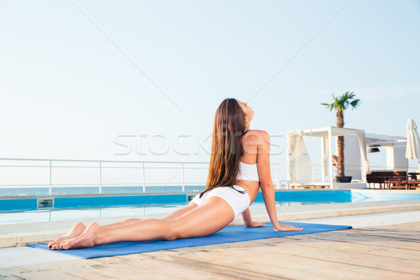 Woman stretching on yoga mat Stock photo © deandrobot