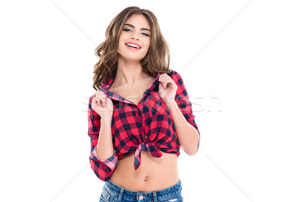 Cheerful pretty young woman in checkered shirt standing and smiling Stock photo © deandrobot