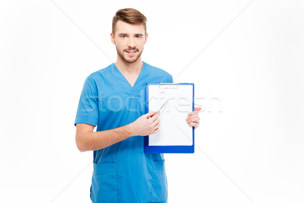 Happy male doctor showing blank clipboard Stock photo © deandrobot