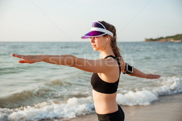 Fitness runner doing warm-up routine on beach before running Stock photo © deandrobot
