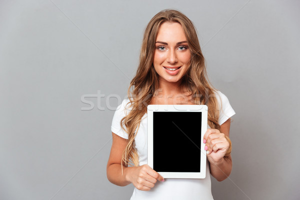 Beautiful young woman showing tablet computer with blank screen Stock photo © deandrobot