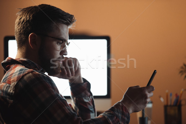 Concentrated bearded web designer chatting by phone. Stock photo © deandrobot