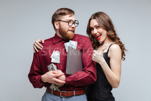 Happy Woman stick to Male nerd with money Stock photo © deandrobot
