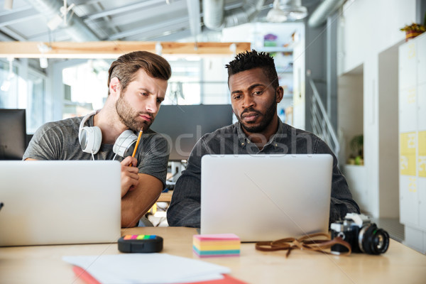 Concentrated young colleagues sitting in office coworking Stock photo © deandrobot