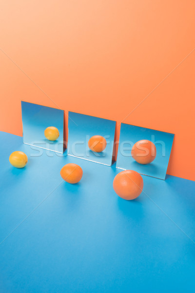 Fruits on blue table isolated over orange background near mirrors Stock photo © deandrobot