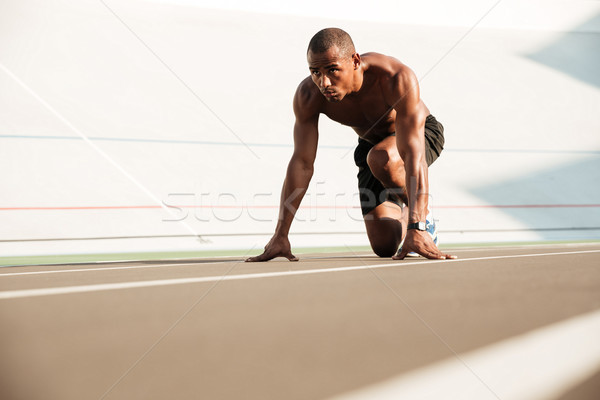 Young african runner starting and preparing to run Stock photo © deandrobot