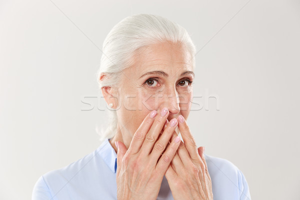 Close-up portrait of charming old lady, covering her mouth with  Stock photo © deandrobot