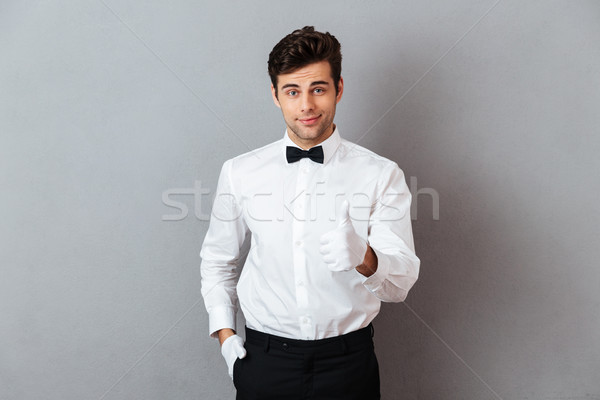 портрет улыбаясь молодые мужчины официант указывая Сток-фото © deandrobot