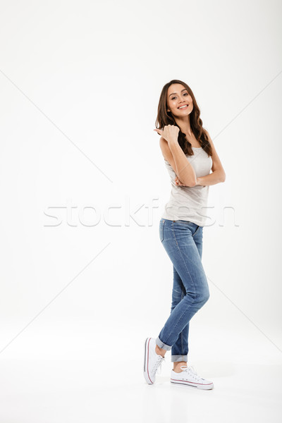 Full length image of Pleased brunette woman posing sideways Stock photo © deandrobot