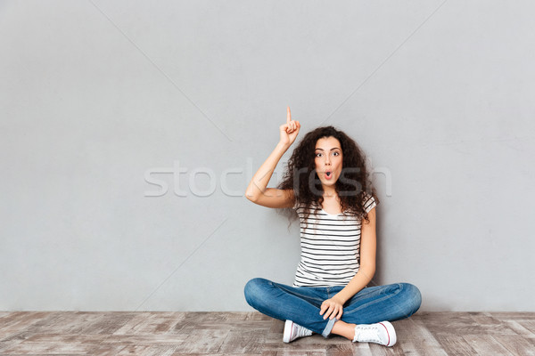 Have idea! Cute woman in casual clothes sitting with legs crosse Stock photo © deandrobot
